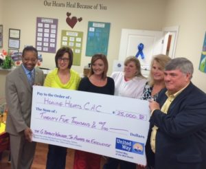 From left, Rev. Kenneth Robinson, Cheryl Beene, Ashley Schachterle, Amber McCormick, Debbie King and John Hornsby hold the check presented by United Way to Healing Hearts CAC.