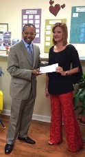 Rev. Kenneth Robinson, United Way President presents check to Ashley Schachterle at Healing Hearts CAC office in Southaven. The check is from the G. Bradley Wanzer Jr. Award for Excellence, given to Healing Hearts.