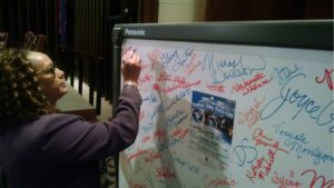 Carolyn Benson, Public Works Maintenance, signs the "We Are The World" poster for United Way at the City of Memphis resource development kickoff.